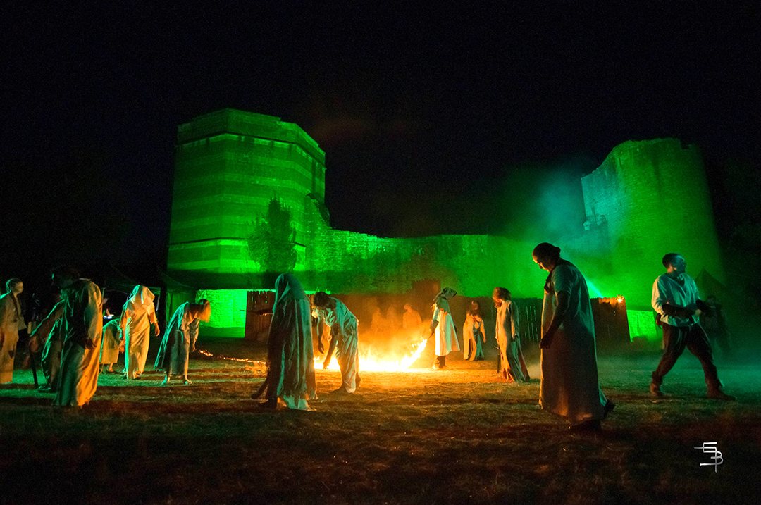 Le château illuminé de vert, une procession autour du feu