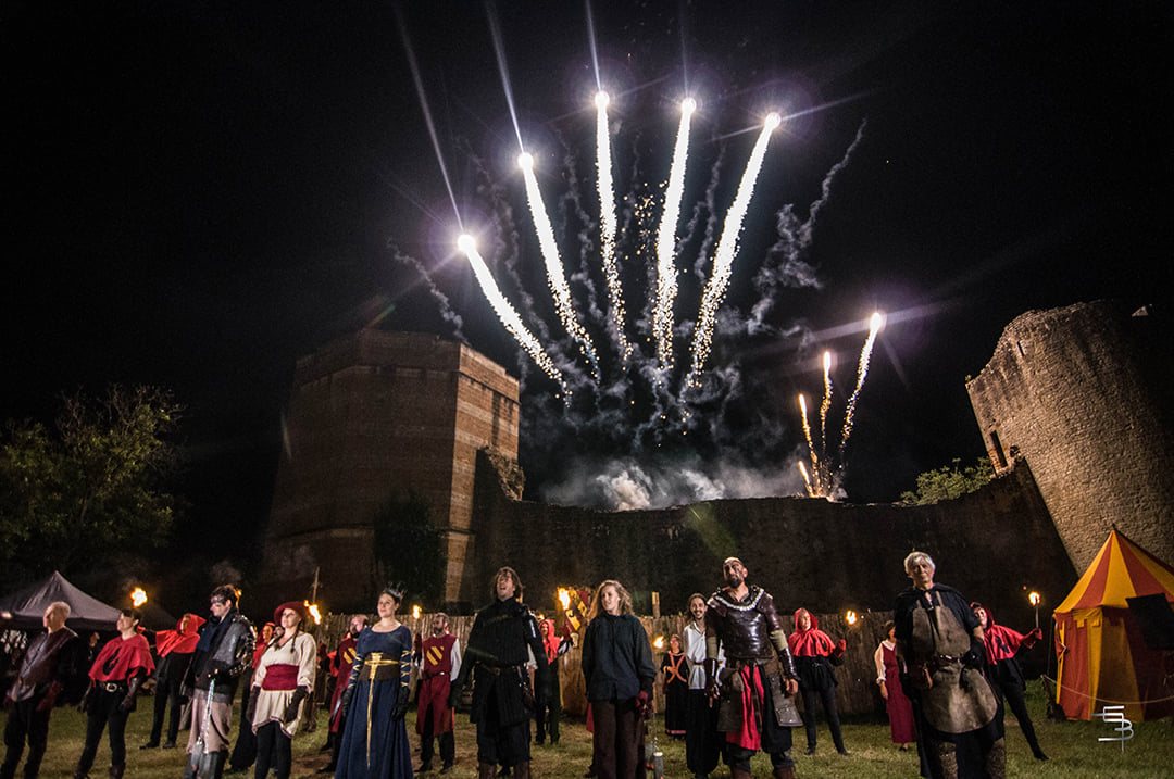 La troupe face au public sous le feu d'artifice final, devant le château